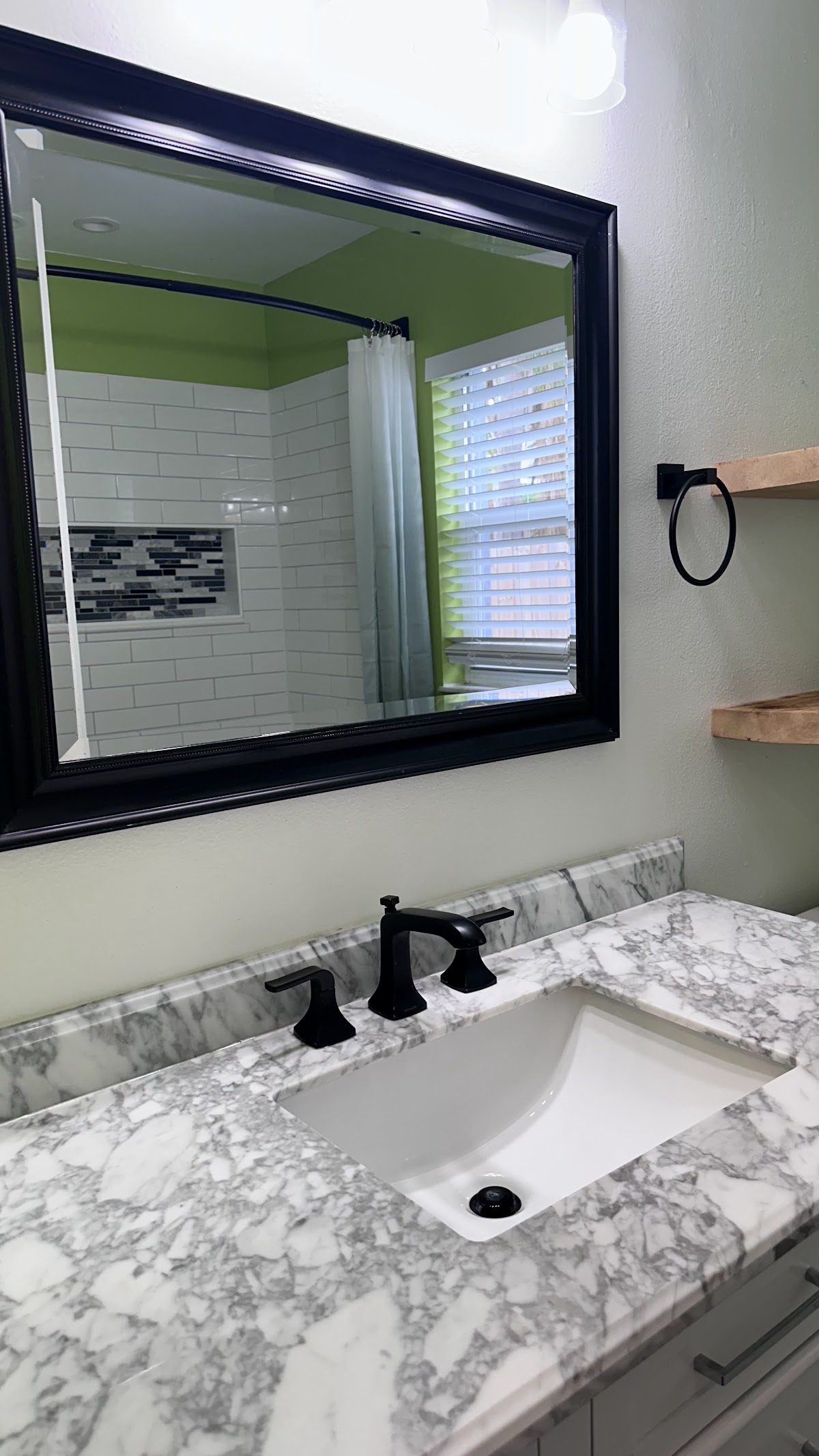Bathroom mirror, sink and marble-pattern countertop
